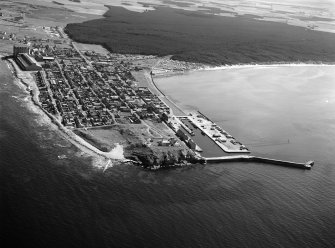 Oblique aerial view centred on the town and harbour of Burghead, looking to the SE.