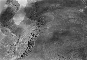 Oblique aerial view centred on the remains of the promontory fort and hut circles at Glenhouses and Strath Howe, looking to the NE.