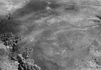 Oblique aerial view centred on the remains of a hut circle at Long Glen, Tore of Troup and Glenhouses, looking to the SE.