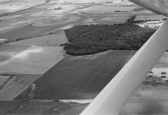 General oblique aerial view centred on the cropmarks of pits at Dalladies, with the quarry and communications intercept station adjacent, looking to the NE.