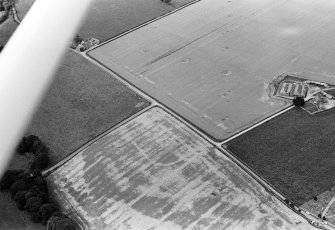 Oblique aerial view centred on the cropmarks of the Roman Temporary Camp at Stracathro, looking to the WNW.