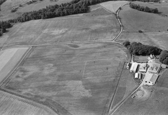 Oblique aerial view centred on the cropmarks of possible enclosures, pits and rig at Kinalty with the farmstead adjacent, looking to the WSW.