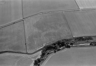 Oblique aerial view centred on the cropmarks of the enclosures, ring ditches and pits at Kirkton and Balmullie Mill, looking to the SE.