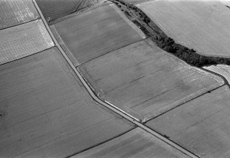 Oblique aerial view centred on the cropmarks of the enclosures, ring ditches and pits at Kirkton and Balmullie Mill, looking to the WSW.