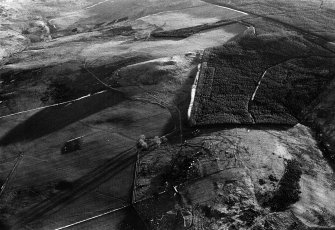 Oblique aerial view centred on the remains of a hut circle, cairns and cultivation remains at Bar Hill, looking to the S.