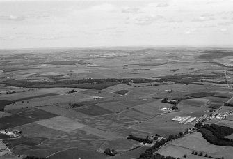 General oblique aerial view centred on the village of Drumoak, the A93 and the surrounding plantations, looking to the ENE.