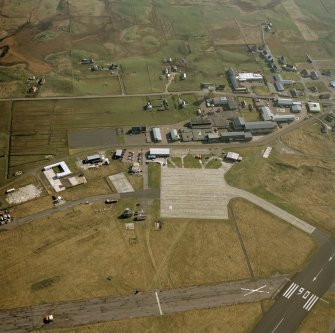 Oblique aerial view centred on Balivanich village with Benbecula airfield adjacent, taken from the NNE.