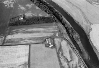 Oblique aerial view centred on the cropmarks of the palisaded enclosure, square and round barrows at Fisherhills, looking to the WNW.