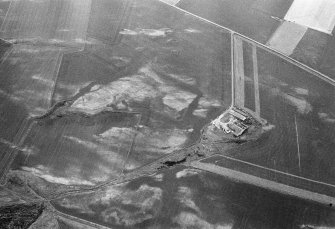 Oblique aerial view centred on the cropmarks of the possible enclosure and linear features at Crowhillock with the farmstead adjacent, looking to the WNW.