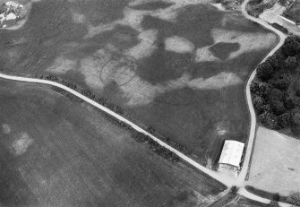 Oblique aerial view centred on the cropmarks of the unenclosed settlement, enclosure and pits at Monboddo House, looking to the NNE.