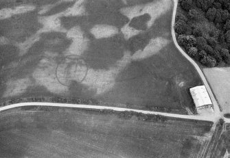 Oblique aerial view centred on the cropmarks of the unenclosed settlement, enclosure and pits at Monboddo House, looking to the ENE.