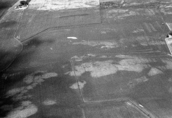 Oblique aerial view centred on the cropmarks of the unenclosed settlement, ring ditch, souterrains and pits at Burnhead of Monboddo, looking to the NNW.