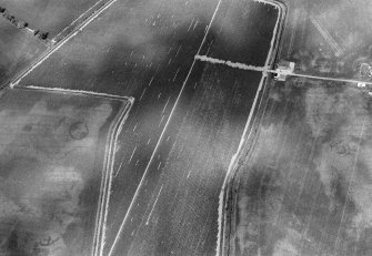 Oblique aerial view centred on the cropmarks of the unenclosed settlement, enclosure and souterrains at Myreside, looking to the NE.