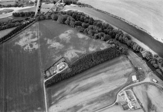 Oblique aerial view centred on the cropmarks of the palisaded enclosure, square and round barrows at Fisherhills, looking to the W.