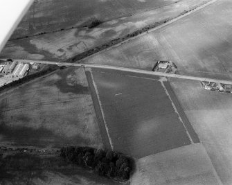 Oblique aerial view centred on the cropmarks of the Roman Temporary Camp, ring ditches, enclosure, lienar features, pits and rig at Dun and Gilrivie, looking to the NNW.