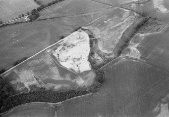 Oblique aerial view centred on the cropmarks of the unenclosed settlement, ring ditches, souterrain, pit alignment, rig and linear features at Arrat's Mill, looking to the NE.