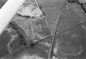 Oblique aerial view centred on the cropmarks of the unenclosed settlement, ring ditches, souterrain, pit alignment, rig and linear features at Arrat's Mill, looking to the W.