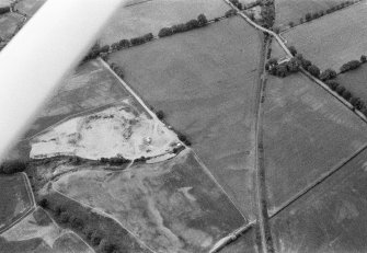 Oblique aerial view centred on the cropmarks of the unenclosed settlement, ring ditches, souterrain, rig and rectinlinear enclosure at Arrat's Mill, looking to the WNW.