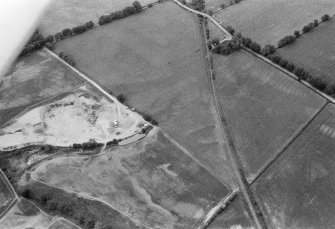 Oblique aerial view centred on the cropmarks of the unenclosed settlement, ring ditches, souterrain, rig and rectinlinear enclosure at Arrat's Mill, looking to the WNW.