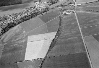 General oblique aerial view centred on the cropmarks of the unenclosed settlement and rig at Milton with Friockheim adjacent, looking to the SSW.