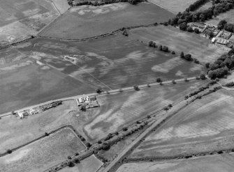 Oblique aerial view centred on the cropmarks of the unenclosed settlement, ring ditches, souterrain, pits and rig at Pitmuies, looking to the WSW.