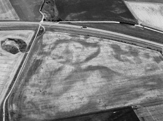 Oblique aerial view centred on the cropmarks of the pit defined cursus and linear features at Purlieknowe, looking to the SE.