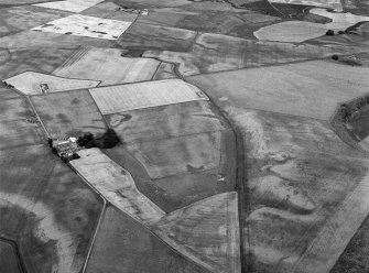 Oblique aerial view centred on the cropmarks of the enclosures, souterrains, barrows, ring ditches, linear features and pits at Newbarns, looking to the NW.