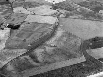Oblique aerial view centred on the cropmarks of the enclosures, souterrains, barrows, ring ditches, linear features and pits at Newbarns, looking to the NNW.