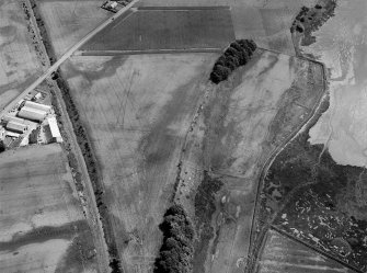 Oblique aerial view centred on the cropmarks of the linear features, Roman temporary camp, pits and rig with the farm adjacent at Gilrivie and Dun, looking to the ESE.