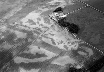 Oblique aerial view centred on the cropmarks of the soutterain, pits and rig at Balrennie with Cairndrum farmstead adjacent, looking to the E.