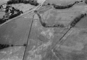 Oblique aerial view centred on the cropmarks of the pit alignment at Bridge of Cruick with Newtonmill House adjacent, looking to the NW.