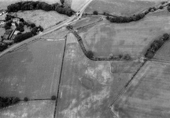 Oblique aerial view centred on the cropmarks of the pit alignment at Bridge of Cruick with Newtonmill House adjacent, looking to the NW.