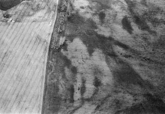 Oblique aerial view centred on the cropmarks of the pit alignment at Bent, looking to the SSE.