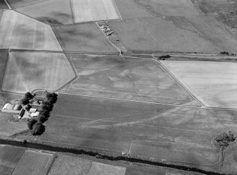 Oblique aerial view centred on the cropmarks of the field system, enclosure, possible ring ditch and frost wedge polygons at Haughs, looking to the WSW.