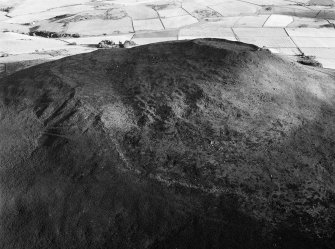 Oblique aerial view centred on the remains of the vitrified fort at Tap O' Noth, looking to the SSW.