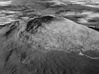 Oblique aerial view centred on the remains of the vitrified fort at Tap O' Noth, looking to the SE.