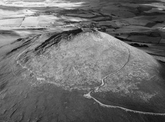 Oblique aerial view centred on the remains of the vitrified fort at Tap O' Noth, looking to the SE.