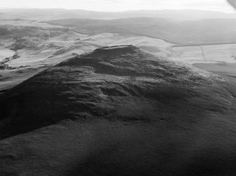 Oblique aerial view centred on the remains of the vitrified fort at Tap O' Noth, looking to the SW.