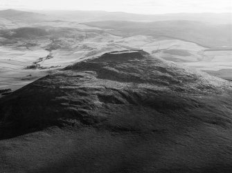 Oblique aerial view centred on the remains of the vitrified fort at Tap O' Noth, looking to the SSW.