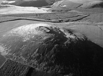 Oblique aerial view centred on the remains of the vitrified fort at Tap O' Noth, looking to the N.