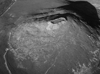 Oblique aerial view centred on the remains of the vitrified fort at Tap O' Noth, looking to the E.