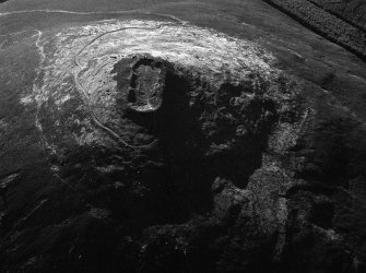 Oblique aerial view centred on the remains of the vitrified fort at Tap O' Noth, looking to the NW.