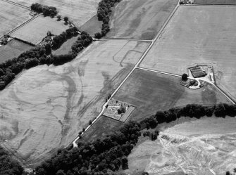 Oblique aerial view centred on the cropmarks of the Roman Temporary Camp, ring ditch and pits with Strathcathro Parish Church adjacent, looking to the SSW.