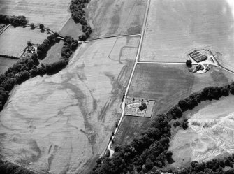 Oblique aerial view centred on the cropmarks of the Roman Temporary Camp, ring ditch and pits with Strathcathro Parish Church adjacent, looking to the SW.