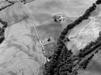 Oblique aerial view centred on the cropmarks of the Roman Temporary Camp, ring ditch and pits with Strathcathro Parish Church adjacent, looking to the WSW.