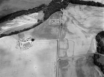 Oblique aerial view centred on the cropmarks of the Roman Temporary Camp, ring ditch and pits with Strathcathro Parish Church adjacent, looking to the NE.