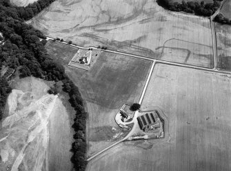 Oblique aerial view centred on the cropmarks of the Roman Temporary Camp, ring ditch and pits with Strathcathro Parish Church adjacent, looking to the E.