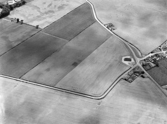 Oblique aerial view centred on the cropmarks of the pit alignment and rig at Inchbare, looking to the SSW.