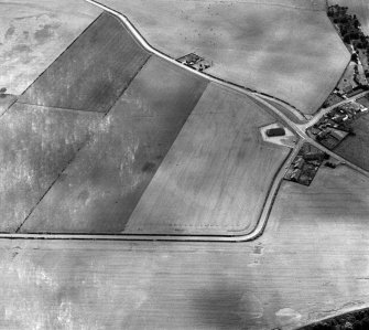 Oblique aerial view centred on the cropmarks of the pit alignment and rig at Inchbare, looking to the SW.