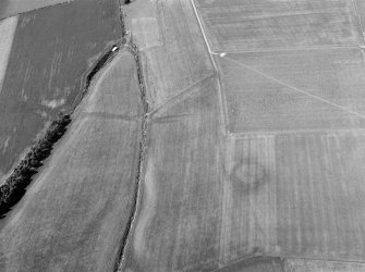 Oblique aerial view centred on the cropmarks of the barrow and rectilinear enclosure at Erskine's Knap, looking to the NW.